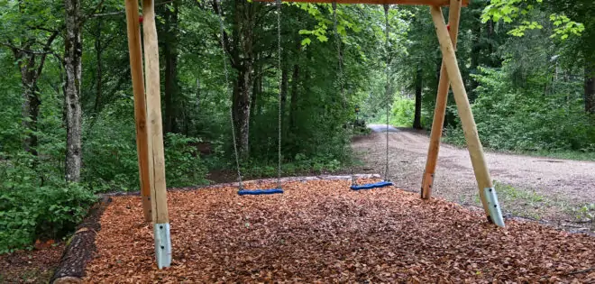 Schaukel auf Spielplatz mit Laub umgeben